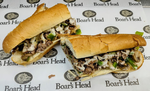 A hot sandwich with peppers and melted cheese on Boar’s Head paper